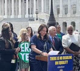 CEO Virginia Kase Solomon at a podium at an Equal Rights Amendment rally